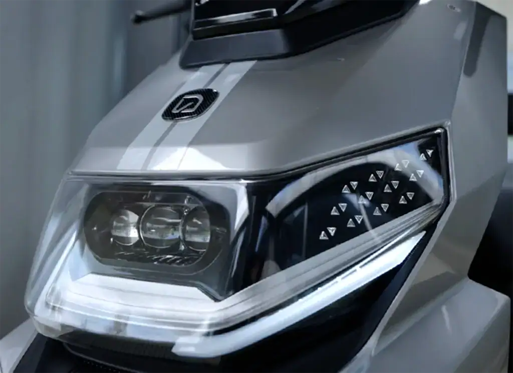 Close-up of a motorcycle headlight showcasing advanced LED lighting technology and stylish design for enhanced visibility and aesthetics.